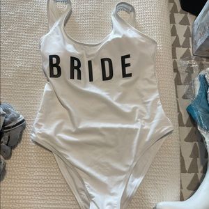 Bride one piece white bathing suit with black letters.